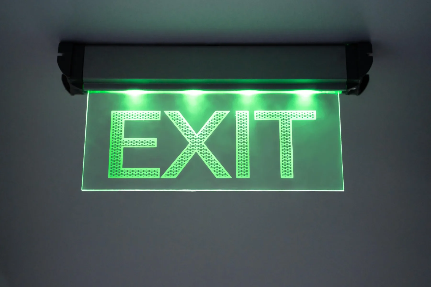 Emergency exit lighting installed below exposed ceiling services